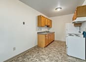 Thumbnail 6 of 10 - A kitchen with white appliances and wooden cabinets.