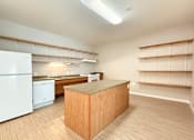 Thumbnail 4 of 20 - A kitchen with a white refrigerator and a wooden island.