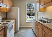 Thumbnail 8 of 15 - A kitchen with a white stove top oven and white refrigerator.