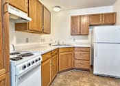 Thumbnail 11 of 16 - A kitchen with a white stove and white refrigerator.