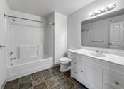 Thumbnail 12 of 40 - A white bathroom with a tiled floor and a large mirror.