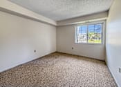 Thumbnail 7 of 40 - A room with a carpeted floor and a window.