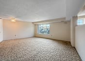 Thumbnail 4 of 40 - A sparsely furnished room with a carpeted floor and a window.