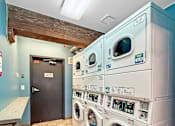 Thumbnail 24 of 34 - A row of washing machines in a laundromat.