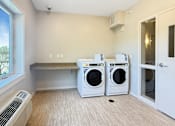 Thumbnail 17 of 20 - A laundry room with a washer and dryer in it.