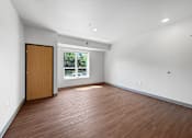 Thumbnail 5 of 35 - A room with a wooden floor and a door leading to a balcony.