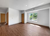 Thumbnail 6 of 35 - A room with wooden floors and white walls.