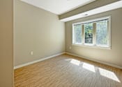 Thumbnail 5 of 20 - A room with a window and wooden flooring.