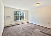 Thumbnail 12 of 16 - A room with a window and a carpeted floor.