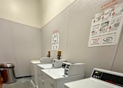 Thumbnail 16 of 20 - A clean, white-walled laundry room with a washer and dryer.