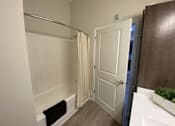 Thumbnail 24 of 31 - A bathroom with a white door and a white sink.