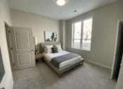 Thumbnail 28 of 31 - A bedroom with a bed, nightstand, and window.
