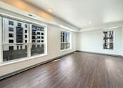 Thumbnail 14 of 21 - A room with wooden floors and a window overlooking a cityscape at The Lumin in the Highland Park neighborhood of St Paul