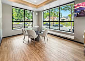 Thumbnail 19 of 22 - A dining room with a table and chairs with a view of the street outside.