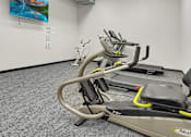 Thumbnail 8 of 19 - A treadmill in a room with a painting on the wall.