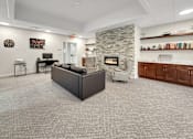 Thumbnail 4 of 19 - A living room with a grey carpet and a stone fireplace.
