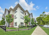 Thumbnail 3 of 19 - A row of houses with a black fence in front.