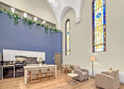 Thumbnail 5 of 27 - A kitchen with a table and chairs in front of a stained glass window.