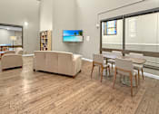 Thumbnail 7 of 27 - A living room with a couch, chairs, and a television.