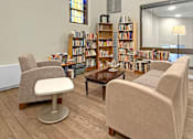 Thumbnail 6 of 27 - A room with a large stained glass window and a bookshelf filled with books.