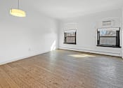 Thumbnail 15 of 27 - A room with wooden flooring and two windows.