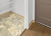 Thumbnail 14 of 27 - A walk in closet with a brown door and a white wall.