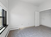 Thumbnail 22 of 27 - A white room with a carpeted floor and a window.