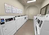 Thumbnail 11 of 27 - A row of washing machines in a laundromat.