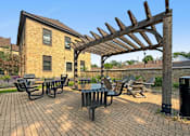Thumbnail 2 of 27 - A patio with a table and chairs under a wooden pergola.