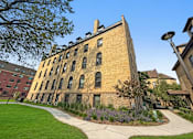 Thumbnail 27 of 27 - A large brick building with a clock tower on the top floor.
