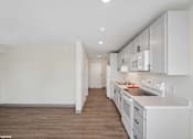 Thumbnail 24 of 58 - A kitchen with white cabinets and a wooden floor.