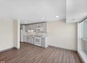 Thumbnail 44 of 58 - A kitchen with white appliances and wood floors.