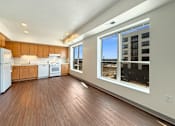 Thumbnail 13 of 21 - A kitchen with wooden floors and white appliances at The Lumin in the Highland Park neighborhood of St Paul
