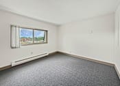 Thumbnail 19 of 29 - A photo of a Liberty Plaza Townhome bedroom with window and carpeted floor