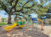 Thumbnail 13 of 28 - A playground with a yellow slide and a green and yellow play structure.