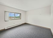 Thumbnail 18 of 29 - A photo of a Liberty Plaza Townhome bedroom with window and carpeted floor