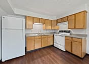 Thumbnail 21 of 29 - A Liberty Plaza Townhome Kitchen with fridge and range and natural cabinets