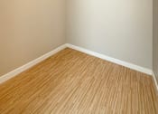 Thumbnail 13 of 20 - Empty room with white shelves and wood flooring.