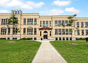 Thumbnail 3 of 35 - A large building with a red roof and a walkway in front.