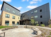 Thumbnail 2 of 35 - A modern building with a circular courtyard in front.