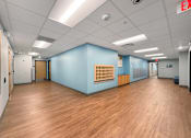 Thumbnail 28 of 35 - A lobby with blue walls and natural looking wood plank flooring