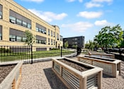 Thumbnail 13 of 35 - A sunny day at at Whittier with a black fence and raised garden beds.