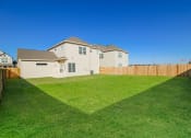 Thumbnail 20 of 22 - a backyard with green grass and a wooden fence