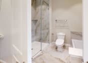 Thumbnail 6 of 40 - a bathroom with a toilet and a glass shower