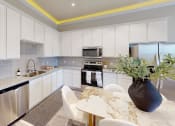 Thumbnail 3 of 40 - a kitchen with white cabinets and a table with white chairs