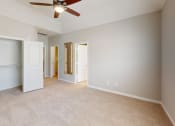 Thumbnail 7 of 40 - an empty living room with a ceiling fan and a closet