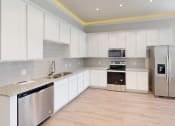 Thumbnail 4 of 40 - a kitchen with white cabinets and a stainless steel refrigerator