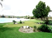 Thumbnail 19 of 40 - a putting green with a lake in the background