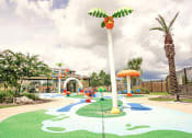 Thumbnail 13 of 40 - a playground with a palm tree and other play equipment
