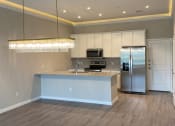 Thumbnail 9 of 40 - a kitchen with a large island and a stainless steel refrigerator